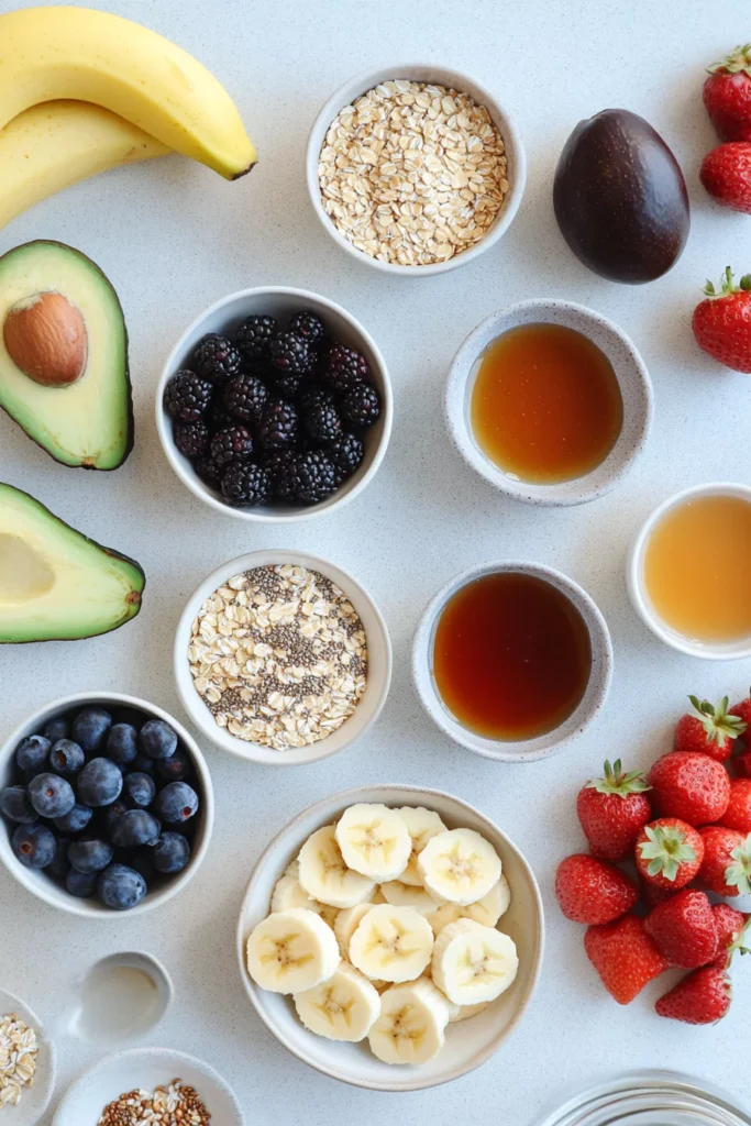 Breakfast Inspired DTI Ideas 2 A flat-lay image of fresh, high-quality breakfast ingredients, including oats, chia seeds, bananas, avocado, berries, honey, and maple syrup on a clean countertop.