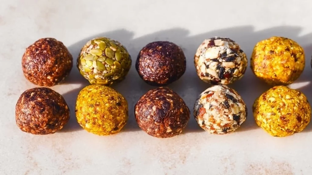 A variety of homemade energy balls made with nuts, seeds, and dried fruit.