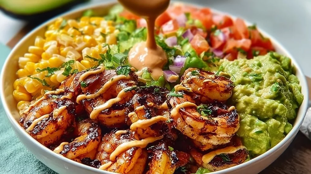 Delicious grilled shrimp bowl with fresh avocado and vibrant vegetables.