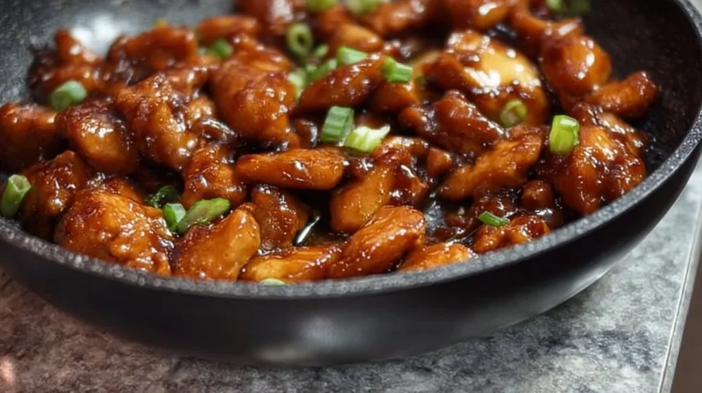 Delicious honey garlic chicken garnished with herbs on a white plate