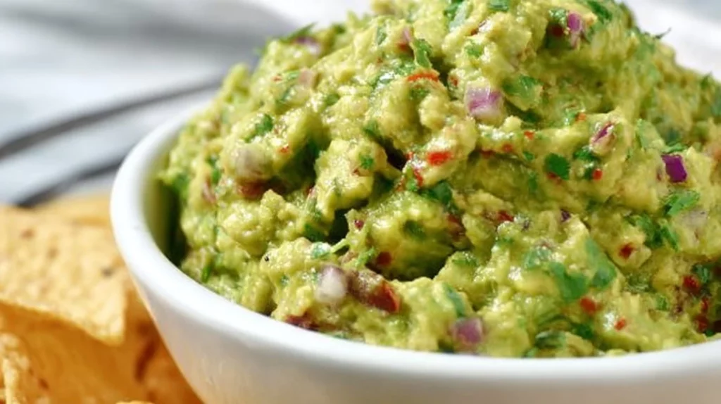 A bowl of Lazy Guacamole with fresh ingredients ready to serve.