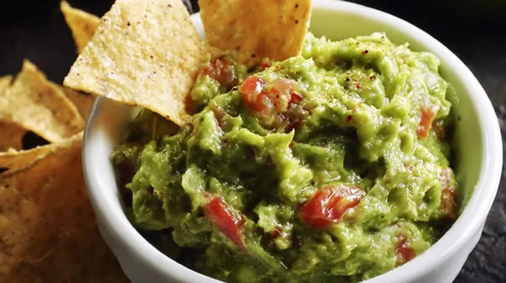 Bowl of Original Mexican Guacamole with fresh avocados and ingredients