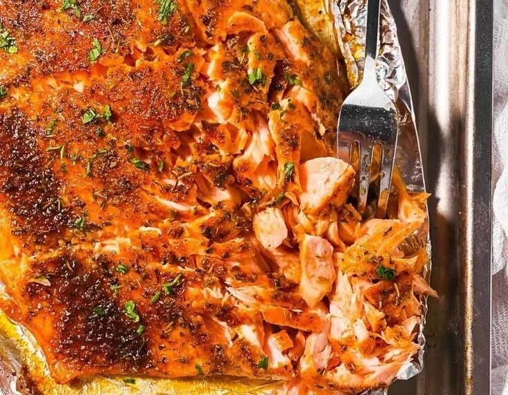 Deliciously cooked oven baked salmon with herbs and lemon on a plate