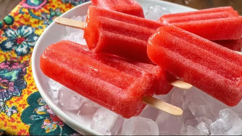 Delicious strawberry popsicles on a wooden table, perfect for summer.