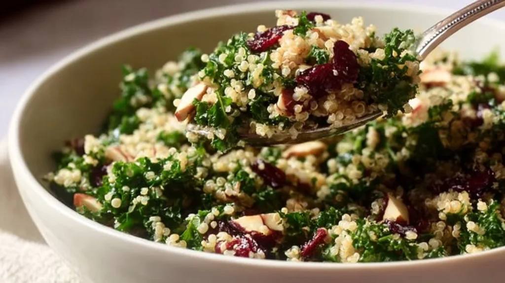A vibrant Kale Cranberry Quinoa Salad topped with nuts and dressing