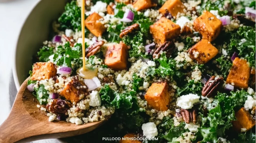 A vibrant roasted sweet potato kale salad garnished with nuts and dressing.